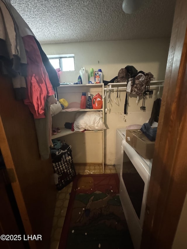 clothes washing area with washing machine and clothes dryer, a textured ceiling, and laundry area