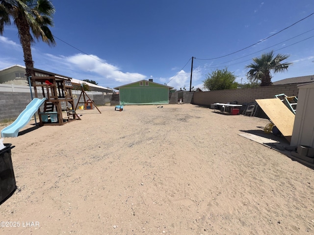 view of yard featuring a fenced backyard and playground community