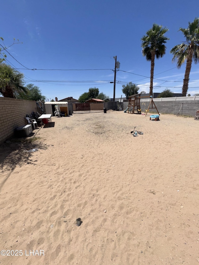 view of yard featuring a playground and fence