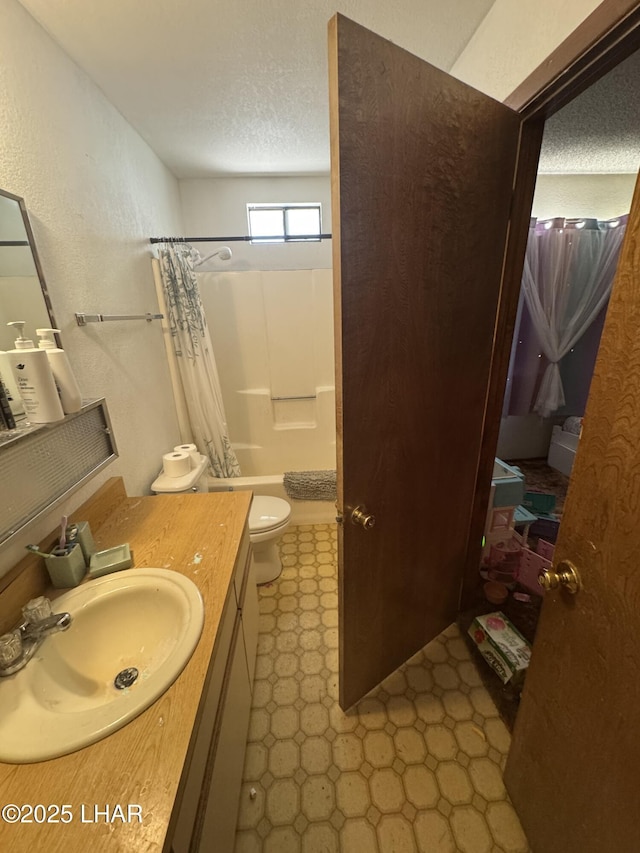 full bath featuring vanity, toilet, tile patterned floors, a textured ceiling, and shower / tub combo