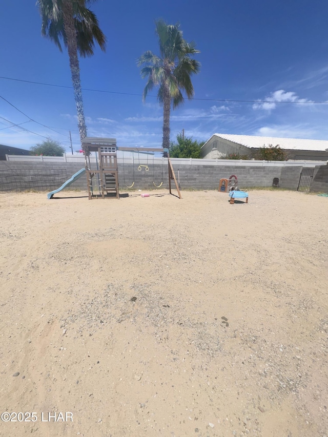 view of yard featuring fence and playground community
