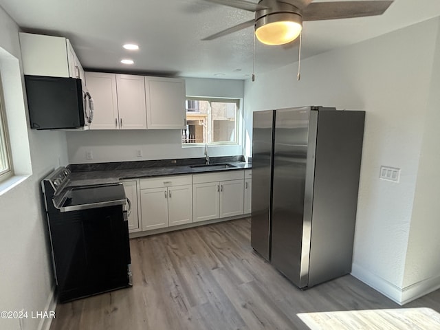 256 Lake Havasu Ave S Unit B75, Lake Havasu City, AZ 86403 - kitchen featuring stainless steel refrigerator, white cabinetry, sink, black range with electric cooktop, and light hardwood / wood-style flooring