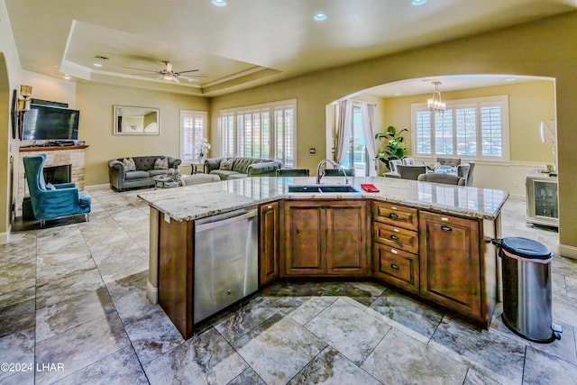 kitchen featuring dishwasher, sink, and a center island with sink