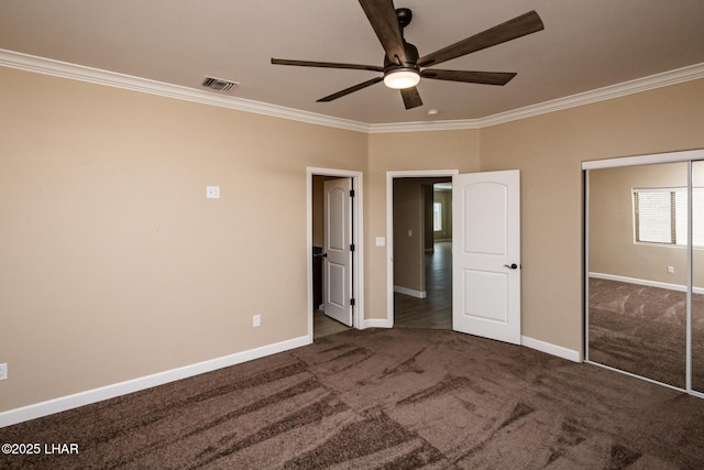 unfurnished bedroom featuring baseboards, visible vents, carpet floors, and ornamental molding