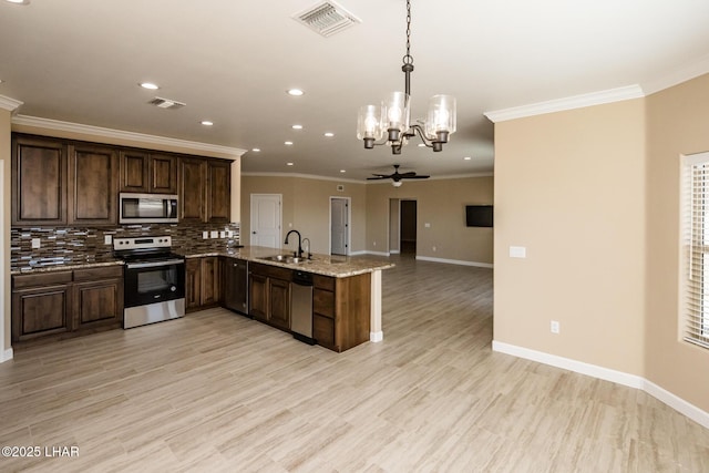 kitchen with a sink, stainless steel appliances, backsplash, and visible vents