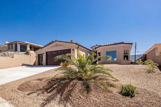 view of front facade with fence, driveway, stucco siding, a garage, and a tile roof