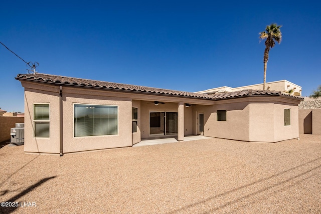 rear view of property with stucco siding, a tiled roof, a ceiling fan, and a patio