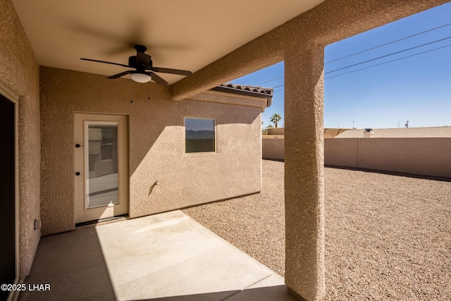 view of patio featuring a ceiling fan and fence