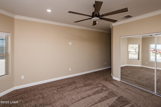 unfurnished bedroom featuring crown molding, carpet, baseboards, and a closet