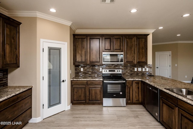 kitchen with stone countertops, tasteful backsplash, dark brown cabinetry, and appliances with stainless steel finishes