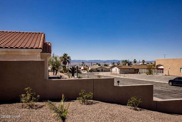 exterior space with a residential view, a mountain view, and fence