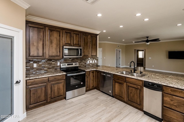 kitchen featuring a sink, light stone countertops, tasteful backsplash, and stainless steel appliances