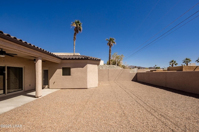 view of yard with a fenced backyard, a patio area, and ceiling fan