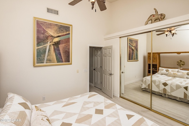 bedroom featuring ceiling fan, light wood finished floors, a closet, and visible vents