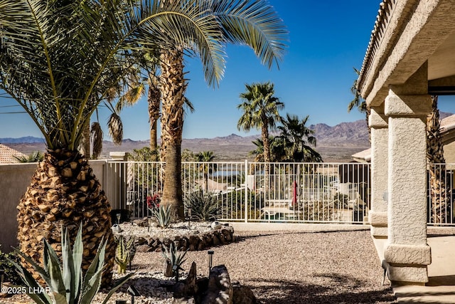 view of gate featuring a mountain view and fence