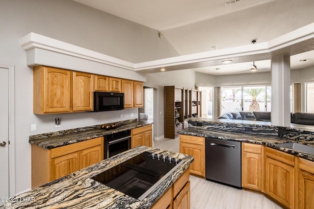 kitchen featuring vaulted ceiling, open floor plan, light wood-type flooring, black appliances, and dark stone countertops