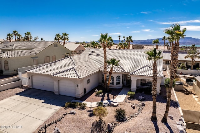 view of front facade with an attached garage, a tile roof, concrete driveway, and stucco siding