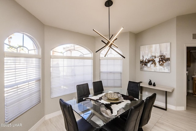 dining area featuring lofted ceiling, an inviting chandelier, visible vents, and baseboards