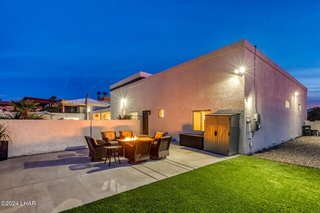 back house at dusk with a patio area and a fire pit