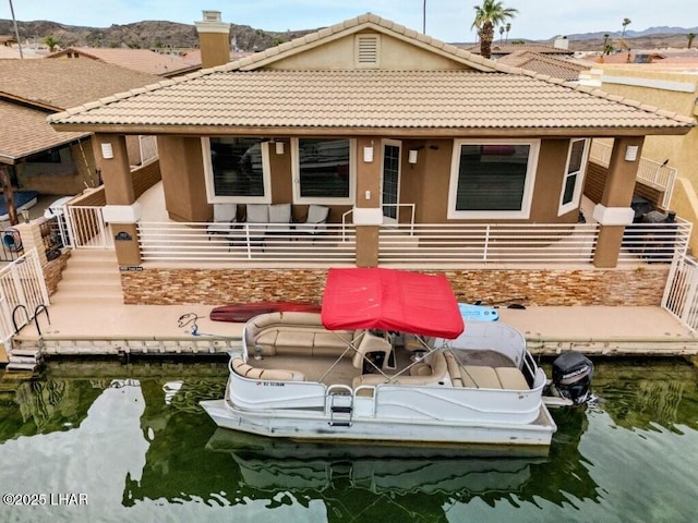 8839 Yaqui Loop, Parker, AZ 85344 - rear view of house with a chimney, stucco siding, a tile roof, and a water view