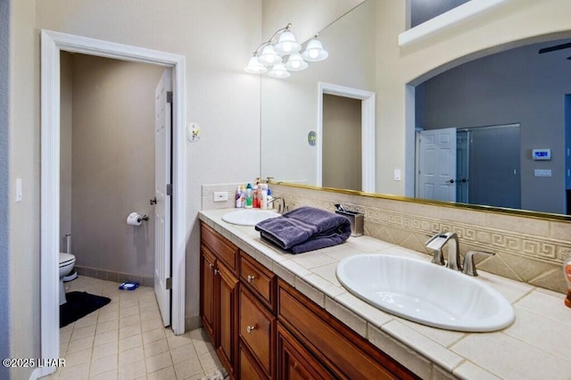 8839 Yaqui Loop, Parker, AZ 85344 - bathroom with toilet, double vanity, decorative backsplash, and tile patterned floors