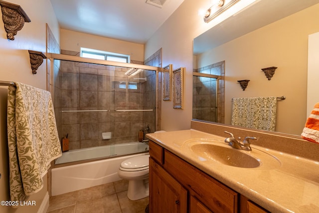 full bathroom with enclosed tub / shower combo, tile patterned floors, toilet, and vanity