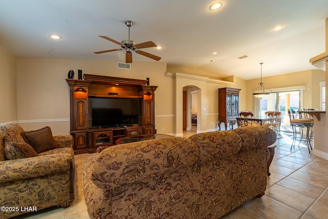 tiled living room with ceiling fan and vaulted ceiling