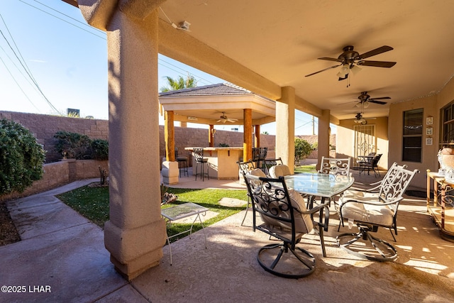 view of patio / terrace with an outdoor bar and ceiling fan