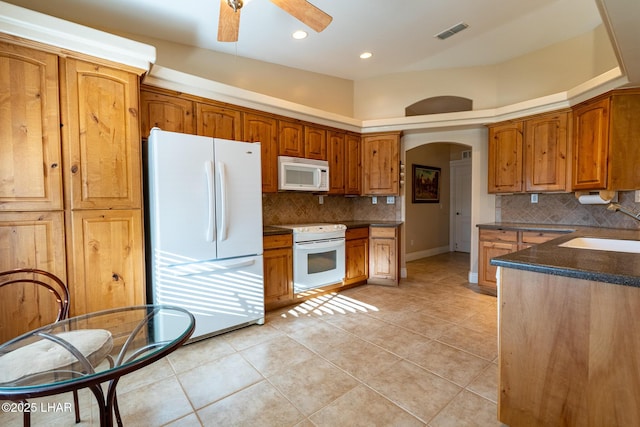 kitchen featuring tasteful backsplash, white appliances, sink, and light tile patterned floors