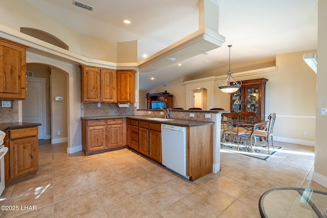 kitchen with dishwasher, a peninsula, dark countertops, and pendant lighting