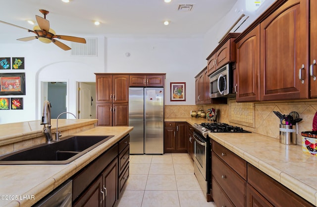 49605 Felspar Ave, Quartzsite, AZ 85346 - kitchen featuring appliances with stainless steel finishes, ceiling fan, decorative backsplash, and light tile patterned floors