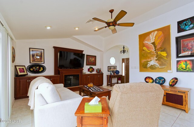 49605 Felspar Ave, Quartzsite, AZ 85346 - living room featuring light tile patterned floors, a ceiling fan, lofted ceiling, and a glass covered fireplace