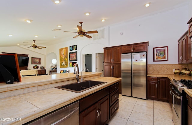 49605 Felspar Ave, Quartzsite, AZ 85346 - kitchen featuring stainless steel appliances, ceiling fan, light tile patterned floors, lofted ceiling, and tile countertops