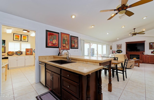 49605 Felspar Ave, Quartzsite, AZ 85346 - kitchen with stainless steel dishwasher, a ceiling fan, a fireplace, tile counters, and light tile patterned floors