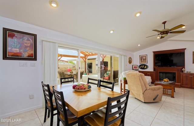 49605 Felspar Ave, Quartzsite, AZ 85346 - dining room featuring lofted ceiling, light tile patterned flooring, a glass covered fireplace, and a ceiling fan