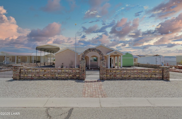 49605 Felspar Ave, Quartzsite, AZ 85346 - view of front of house featuring a fenced front yard, a carport, a gate, and stucco siding