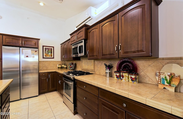 49605 Felspar Ave, Quartzsite, AZ 85346 - kitchen featuring stainless steel appliances, dark brown cabinets, tasteful backsplash, and light tile patterned flooring