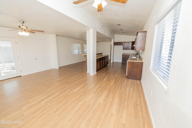 31447 Marine Dr, Parker, AZ 85344 - unfurnished living room featuring visible vents, baseboards, a sink, ceiling fan, and light wood-style floors