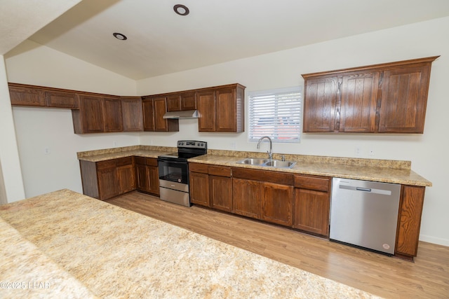 31447 Marine Dr, Parker, AZ 85344 - kitchen with appliances with stainless steel finishes, under cabinet range hood, a sink, lofted ceiling, and light wood finished floors