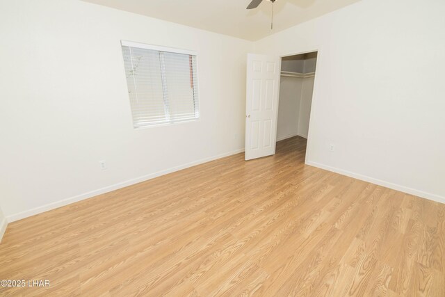 31447 Marine Dr, Parker, AZ 85344 - unfurnished bedroom with a closet, baseboards, ceiling fan, a walk in closet, and light wood-style flooring