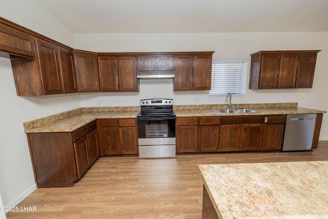 31447 Marine Dr, Parker, AZ 85344 - kitchen featuring under cabinet range hood, light wood finished floors, a sink, and stainless steel appliances