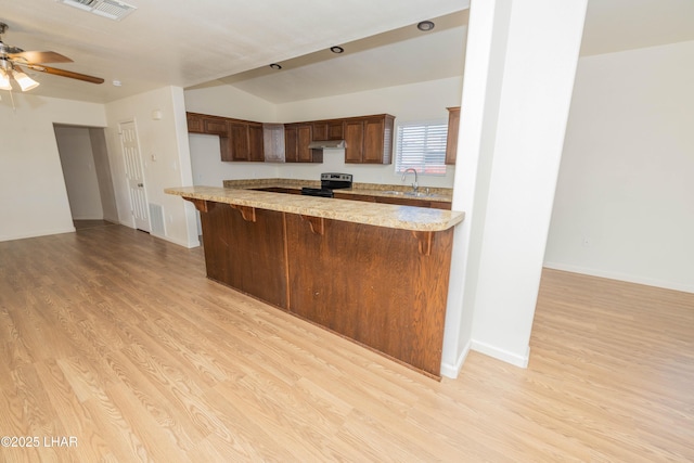 31447 Marine Dr, Parker, AZ 85344 - kitchen featuring stainless steel range with electric stovetop, under cabinet range hood, light wood finished floors, and visible vents