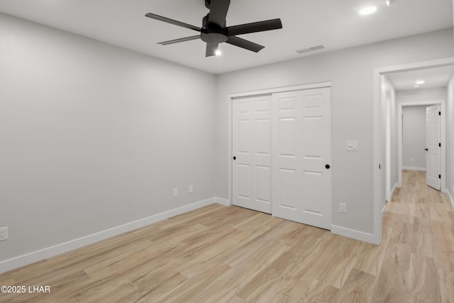 unfurnished bedroom with light wood-style floors, visible vents, baseboards, and a closet