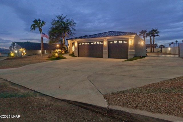 exterior space featuring a garage, driveway, a gate, and stucco siding