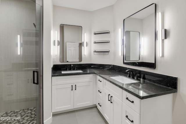 bathroom featuring tile patterned floors, a sink, a shower stall, and double vanity