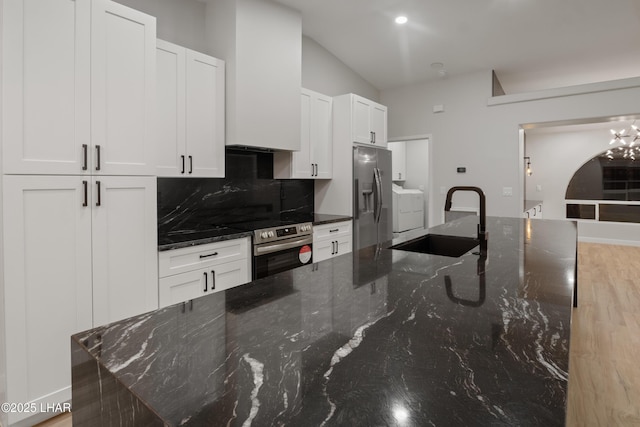 kitchen with wall oven, stainless steel fridge, tasteful backsplash, white cabinetry, and a sink