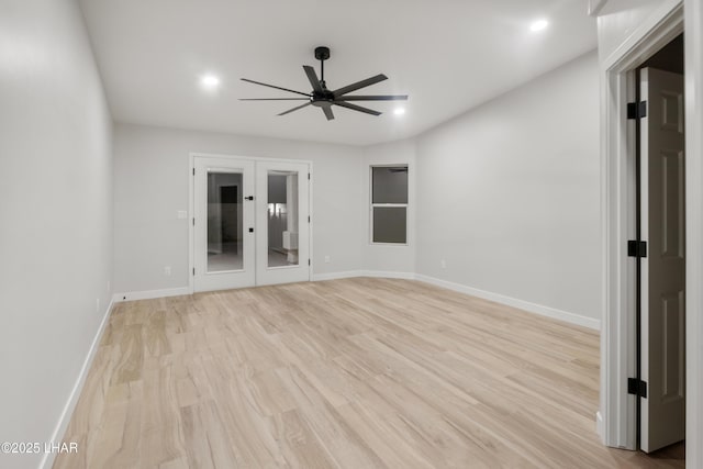 spare room featuring light wood-style floors, ceiling fan, baseboards, and french doors