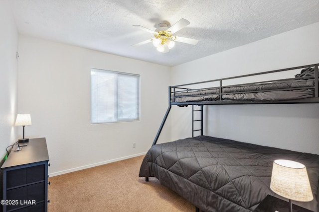 bedroom with carpet flooring, a ceiling fan, baseboards, and a textured ceiling