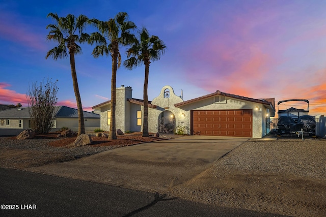 view of front of home featuring concrete driveway, stucco siding, an attached garage, and a chimney