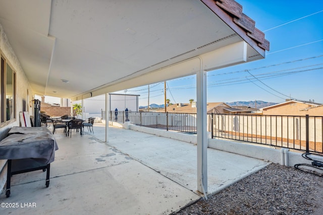 view of patio / terrace with outdoor dining area, a fenced backyard, and a mountain view